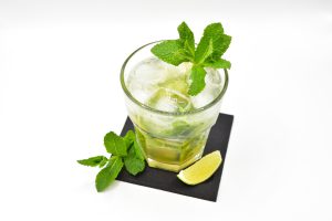 Widok pod skosem na szklankę tylpu old fashioned. W środku bezalkoholwy koktajl Virgin Mojito